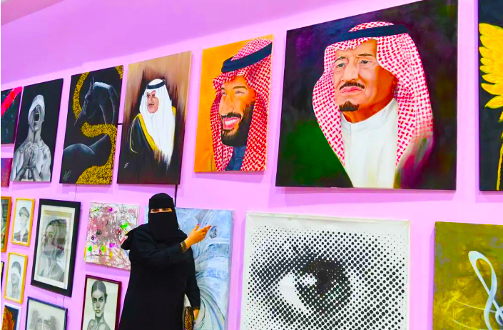 الفنانة ثنوى بجانب لوحاتها